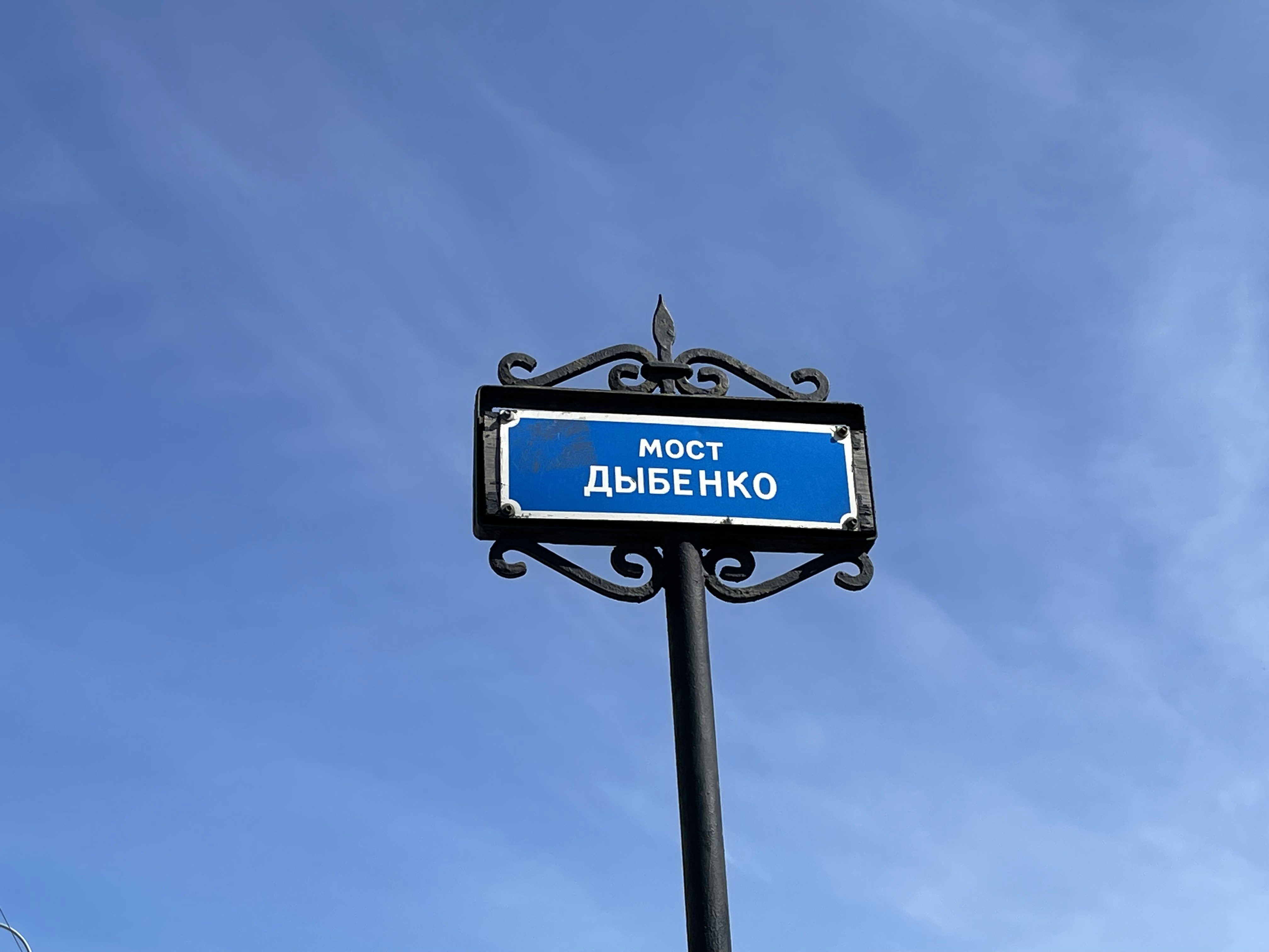 a blue street sign on a black pole